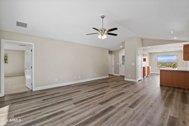 unfurnished living room with wood-type flooring, vaulted ceiling, and ceiling fan