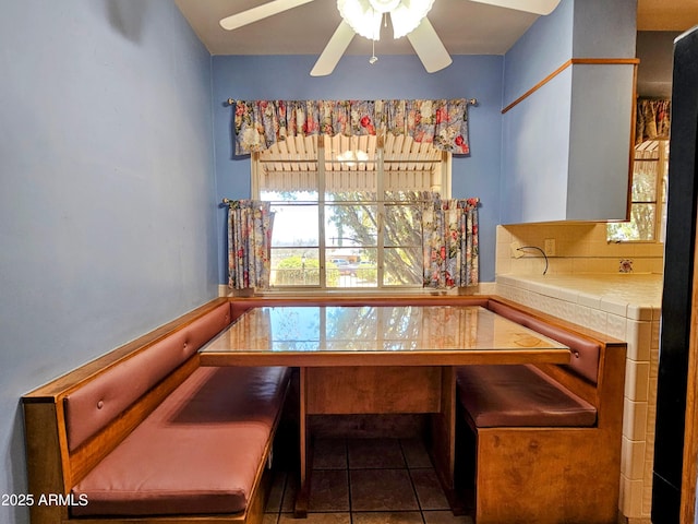 dining area featuring breakfast area, tile patterned flooring, and a ceiling fan