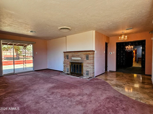 unfurnished living room with a brick fireplace, carpet floors, a notable chandelier, and visible vents