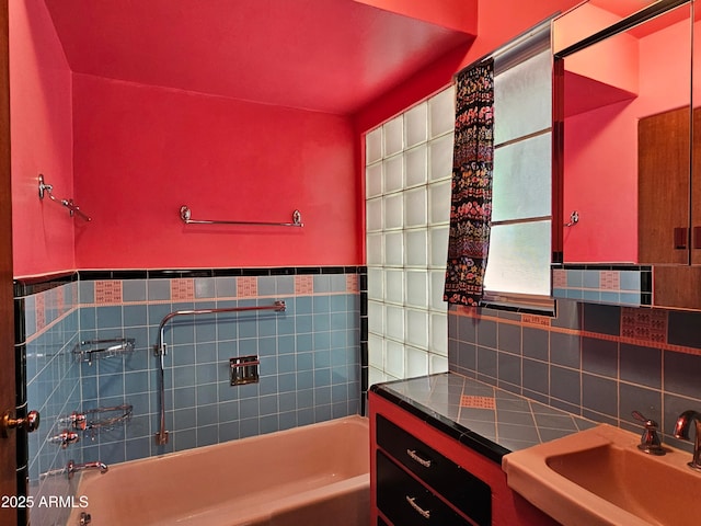 full bath featuring a wainscoted wall, a sink, and tile walls