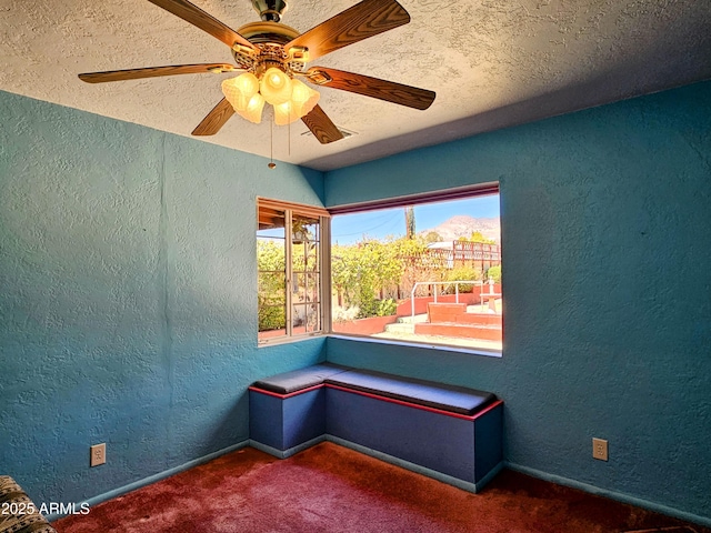 unfurnished room with carpet floors, a textured ceiling, a textured wall, and a ceiling fan