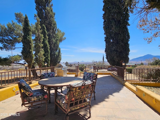view of patio with a mountain view and outdoor dining space