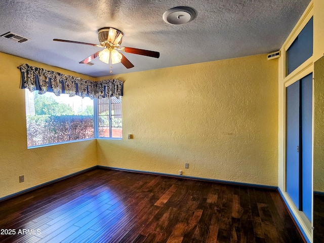 empty room featuring wood finished floors, ceiling fan, and a textured wall