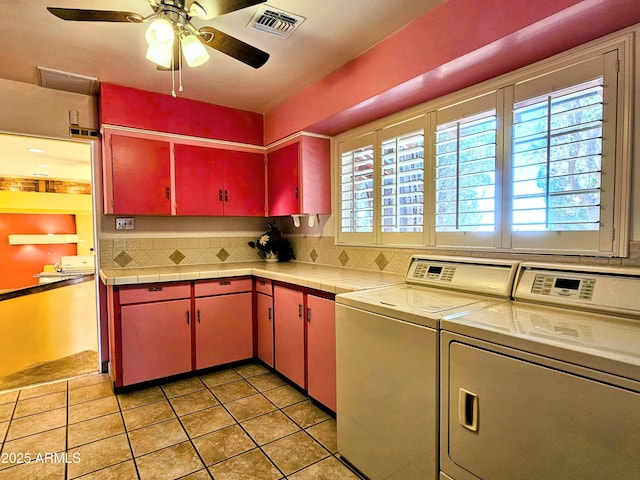 kitchen with washing machine and dryer, a ceiling fan, tasteful backsplash, visible vents, and red cabinets