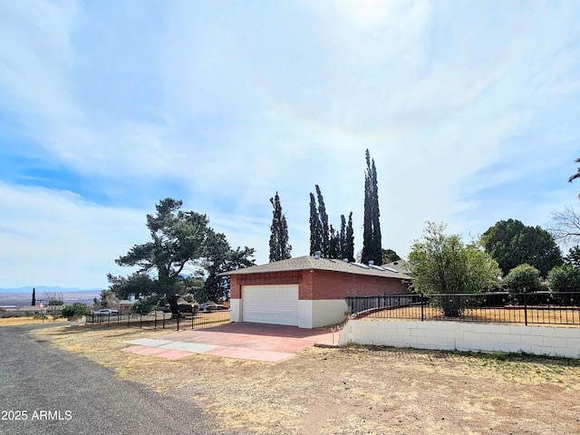 view of side of property with driveway and fence