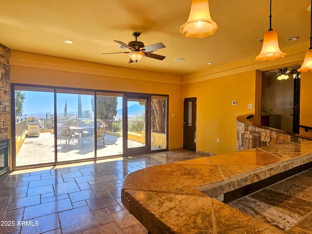 interior space with ornamental molding, recessed lighting, a ceiling fan, and stone tile floors