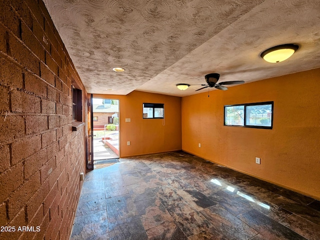 spare room with baseboards, a textured ceiling, and a healthy amount of sunlight