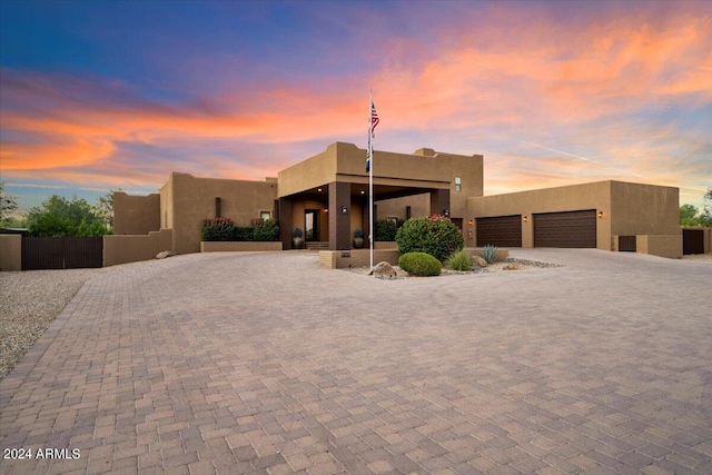 pueblo revival-style home featuring a garage