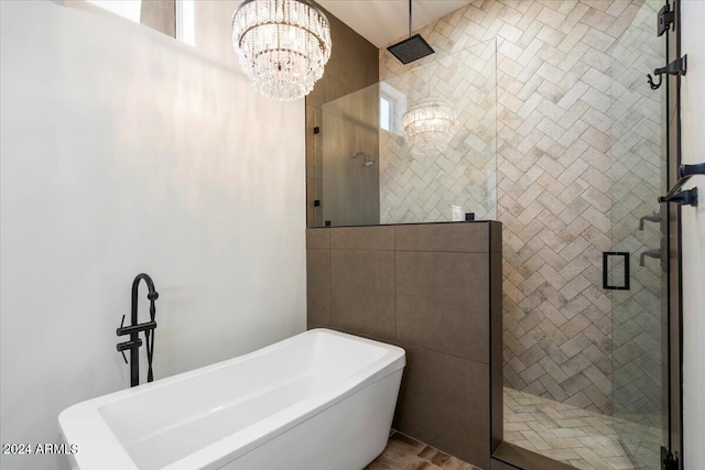 bathroom featuring shower with separate bathtub and a chandelier