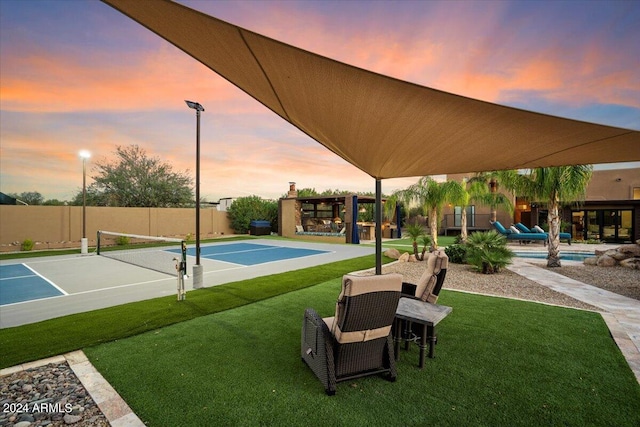 view of community with a lawn, tennis court, and a swimming pool