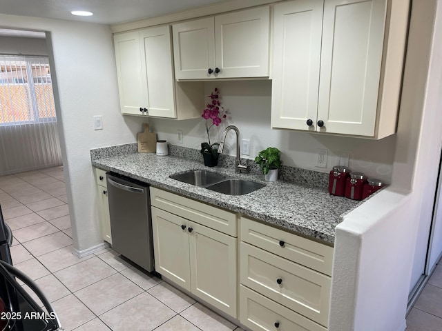 kitchen featuring light stone counters, sink, light tile patterned floors, and dishwasher