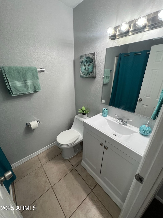 bathroom featuring vanity, tile patterned floors, and toilet