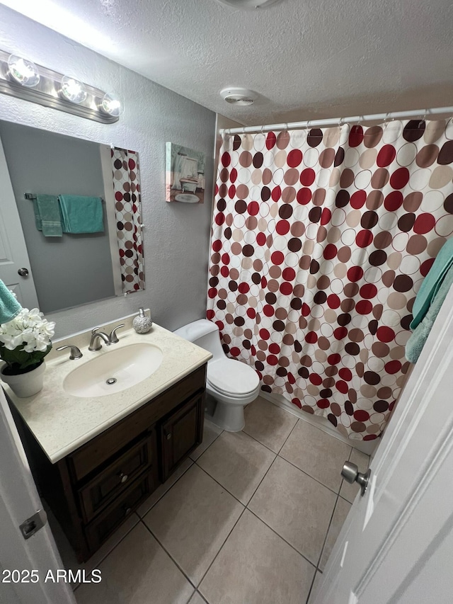 bathroom featuring tile patterned floors, vanity, toilet, and a textured ceiling