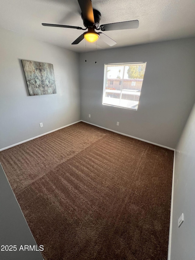 carpeted empty room with ceiling fan and a textured ceiling