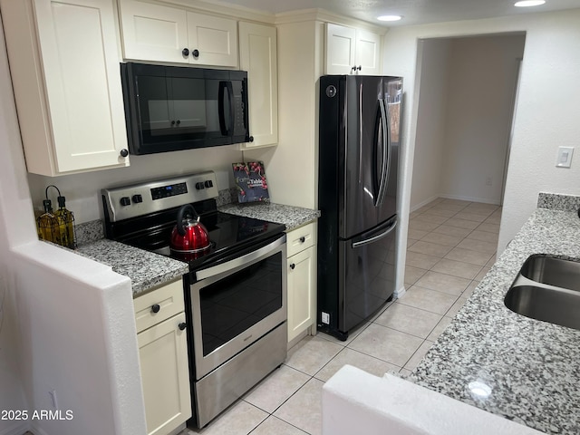 kitchen featuring light stone countertops, sink, light tile patterned floors, and black appliances