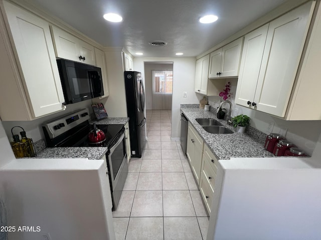 kitchen with white cabinetry, light tile patterned floors, sink, and black appliances