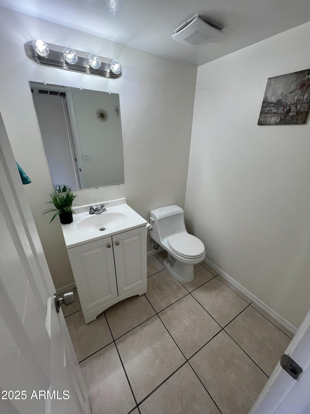 bathroom with tile patterned flooring, vanity, and toilet