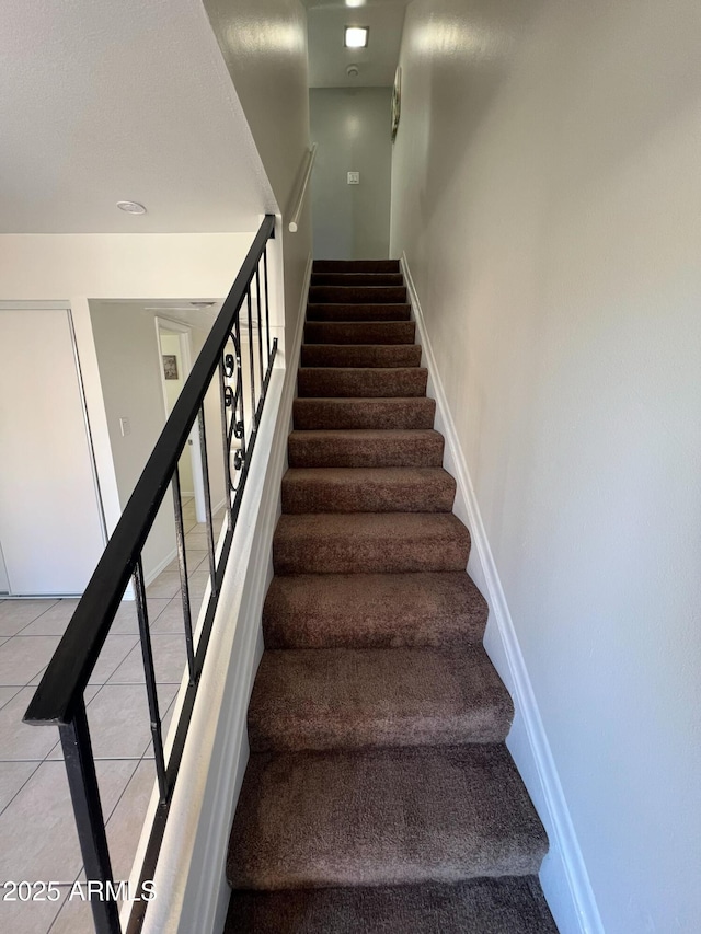 staircase featuring tile patterned floors