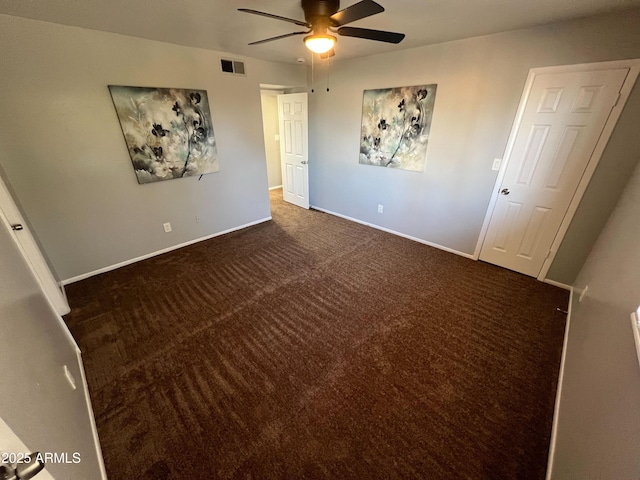 unfurnished bedroom with ceiling fan and dark carpet