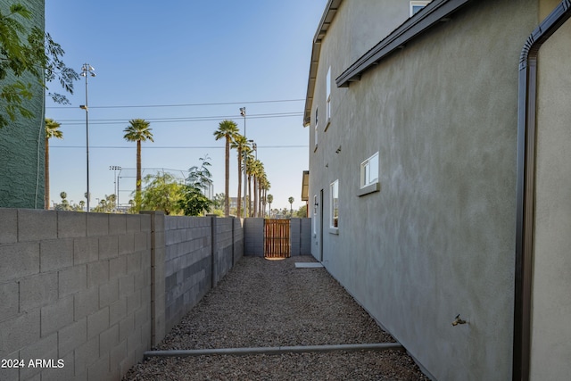 view of side of property with a fenced backyard and stucco siding