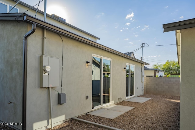 back of property with stucco siding and fence