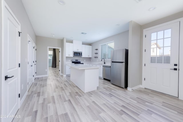 kitchen featuring visible vents, light countertops, white cabinets, appliances with stainless steel finishes, and a center island