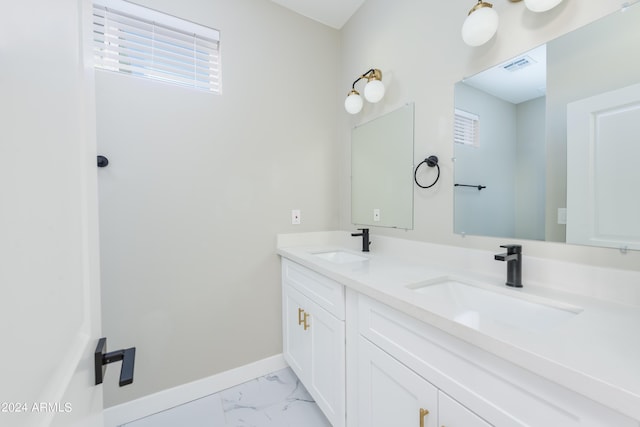 bathroom featuring a sink, visible vents, baseboards, and marble finish floor