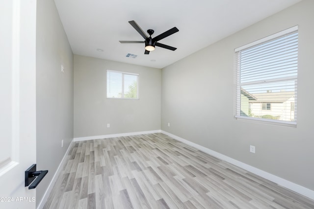 empty room featuring light wood-style flooring, a ceiling fan, and baseboards