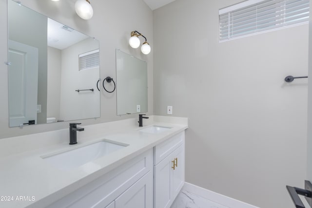 bathroom with double vanity, visible vents, marble finish floor, and a sink