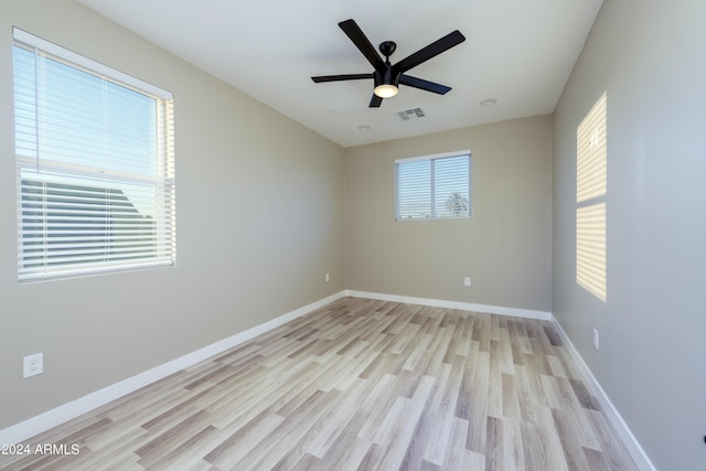 unfurnished room featuring visible vents, baseboards, a ceiling fan, and light wood finished floors