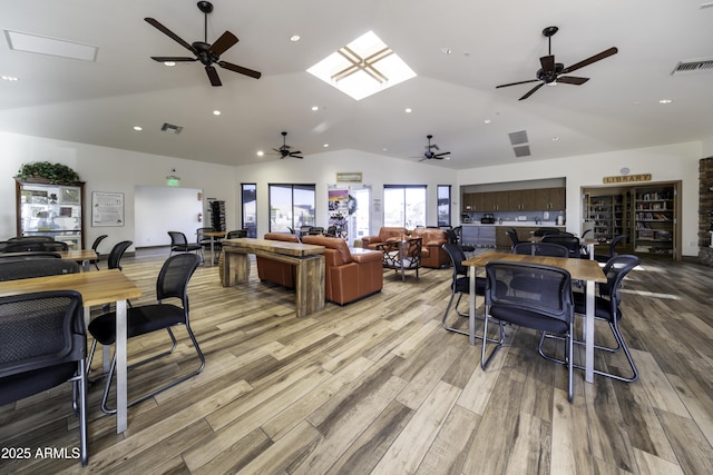 dining area featuring vaulted ceiling and light hardwood / wood-style flooring