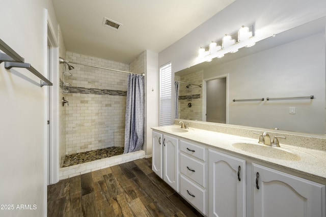 bathroom with curtained shower, vanity, and wood-type flooring