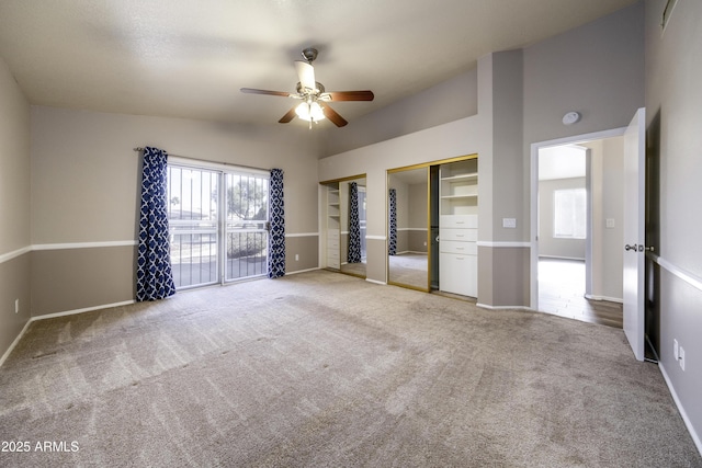 unfurnished bedroom with multiple closets, ceiling fan, lofted ceiling, access to outside, and carpet