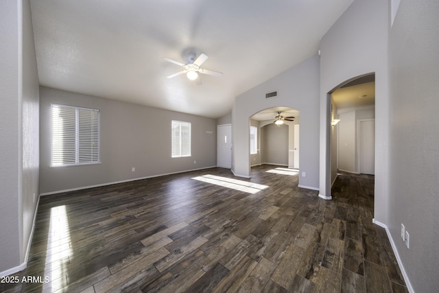 unfurnished living room with ceiling fan, high vaulted ceiling, and dark wood-type flooring