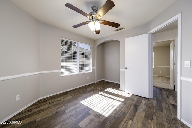 unfurnished bedroom featuring ceiling fan and dark wood-type flooring