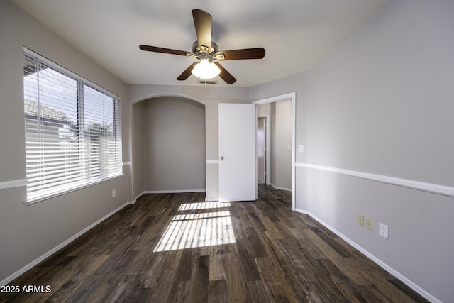 unfurnished room with ceiling fan and dark wood-type flooring