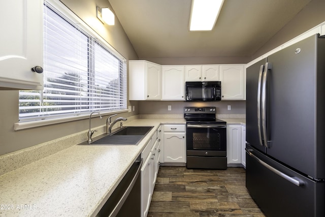 kitchen with sink, white cabinetry, lofted ceiling, and black appliances