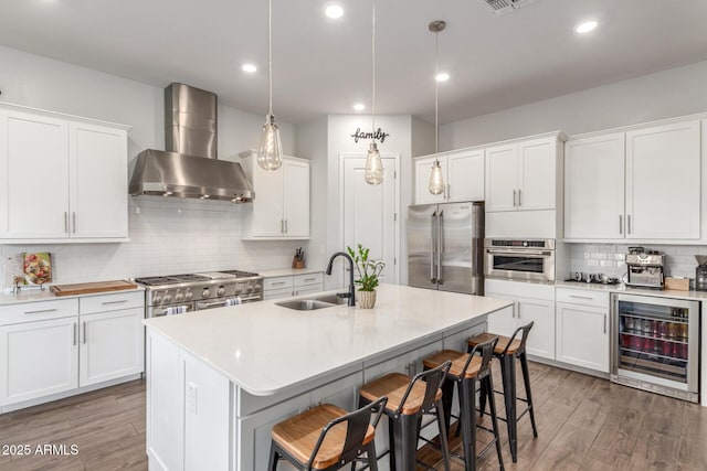 9764 E Thornbush Ave, Mesa, AZ 85212 - kitchen with wall chimney range hood, a sink, beverage cooler, premium appliances, and light wood-type flooring
