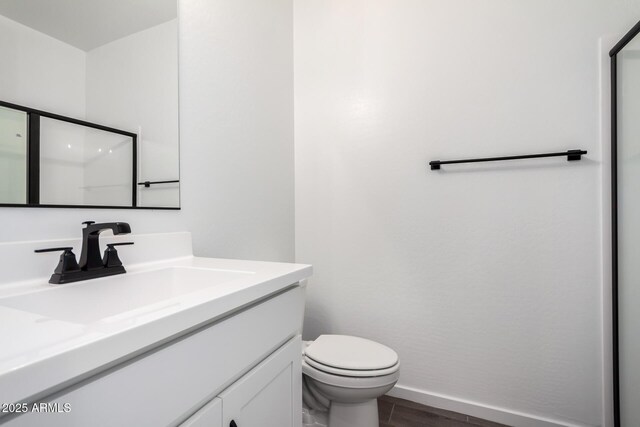 11627 W Green Dr, Youngtown, AZ 85363 - full bath with wood finished floors, vanity, toilet, a shower with shower door, and baseboards