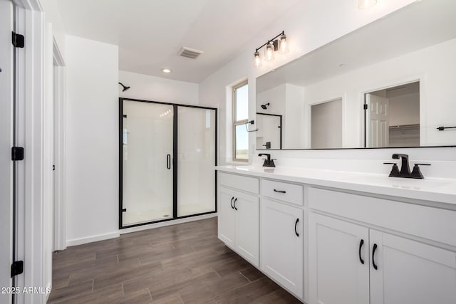 11627 W Green Dr, Youngtown, AZ 85363 - bathroom with a stall shower, double vanity, wood finished floors, and recessed lighting