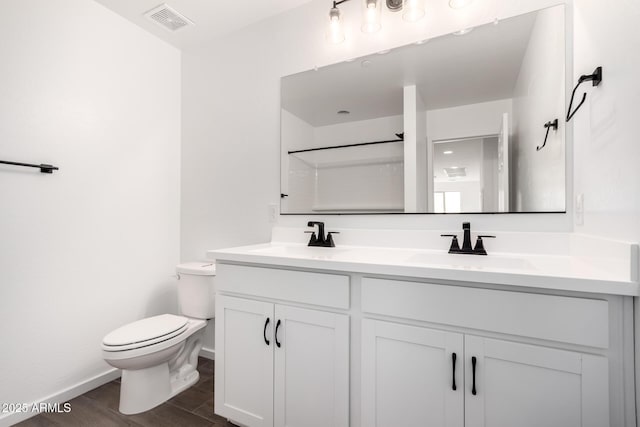 11627 W Green Dr, Youngtown, AZ 85363 - full bathroom with toilet, wood finished floors, double vanity, baseboards, and a shower