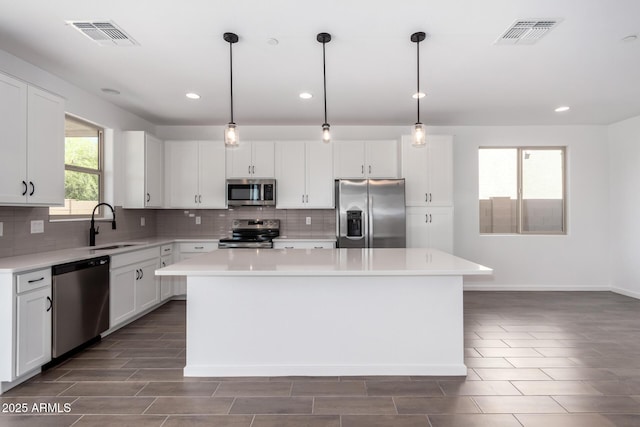 11627 W Green Dr, Youngtown, AZ 85363 - kitchen featuring appliances with stainless steel finishes, a sink, a center island, backsplash, and light countertops