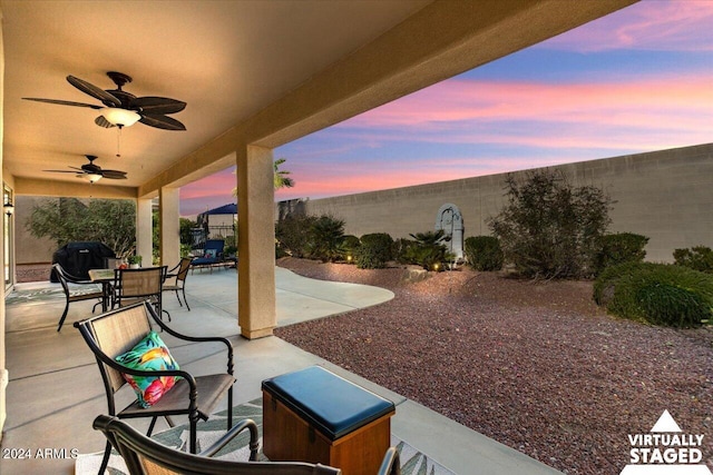 patio terrace at dusk with a grill and ceiling fan