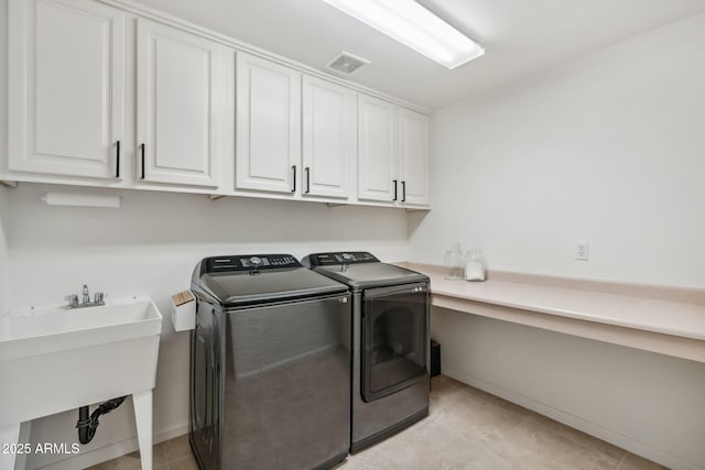 laundry room with cabinets, separate washer and dryer, and sink