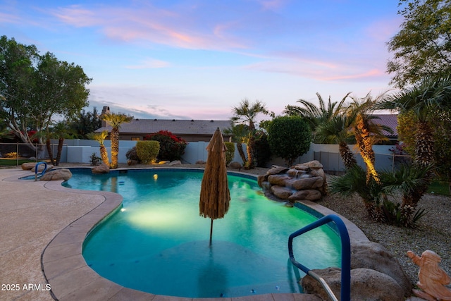 pool at dusk with a patio