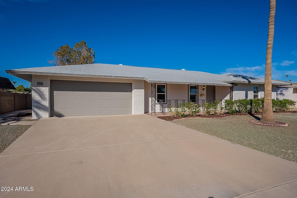 single story home with covered porch and a garage