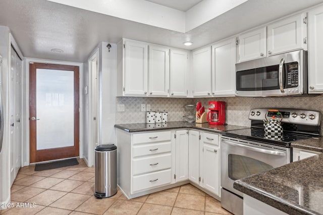 kitchen with light tile patterned floors, stainless steel appliances, tasteful backsplash, and white cabinets