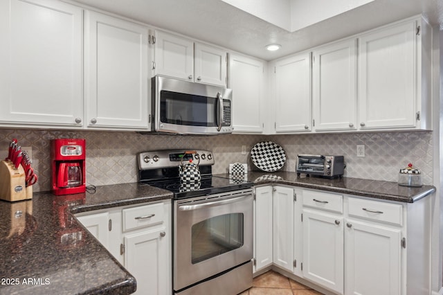 kitchen with decorative backsplash, appliances with stainless steel finishes, and white cabinetry