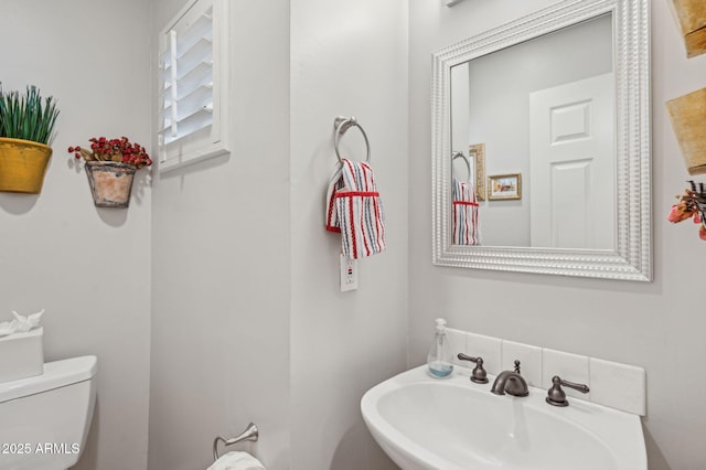 half bathroom with toilet and a sink