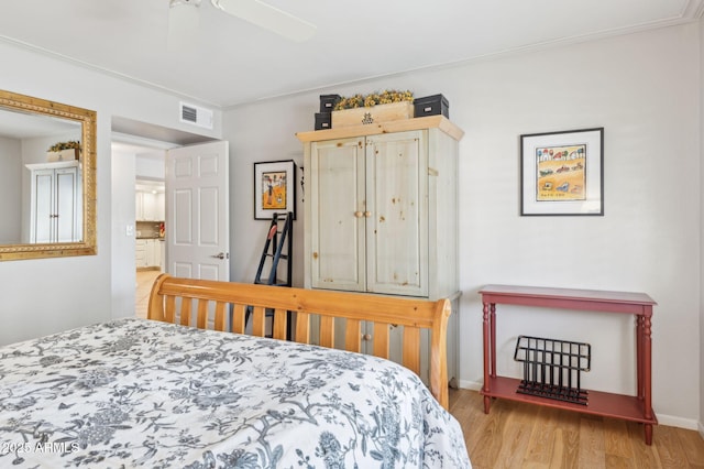 bedroom with visible vents, baseboards, and wood finished floors